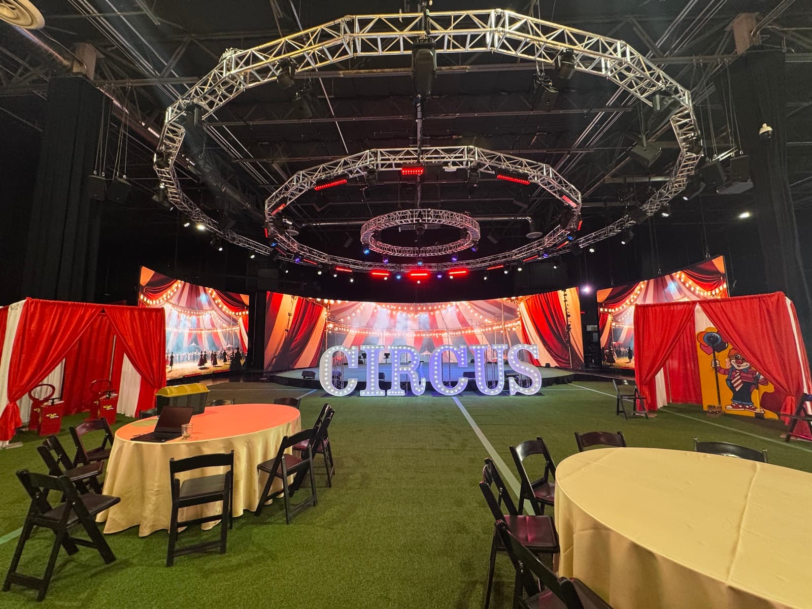 Circus-themed event with big-top backdrop, marquee CIRCUS letters and red drape booths